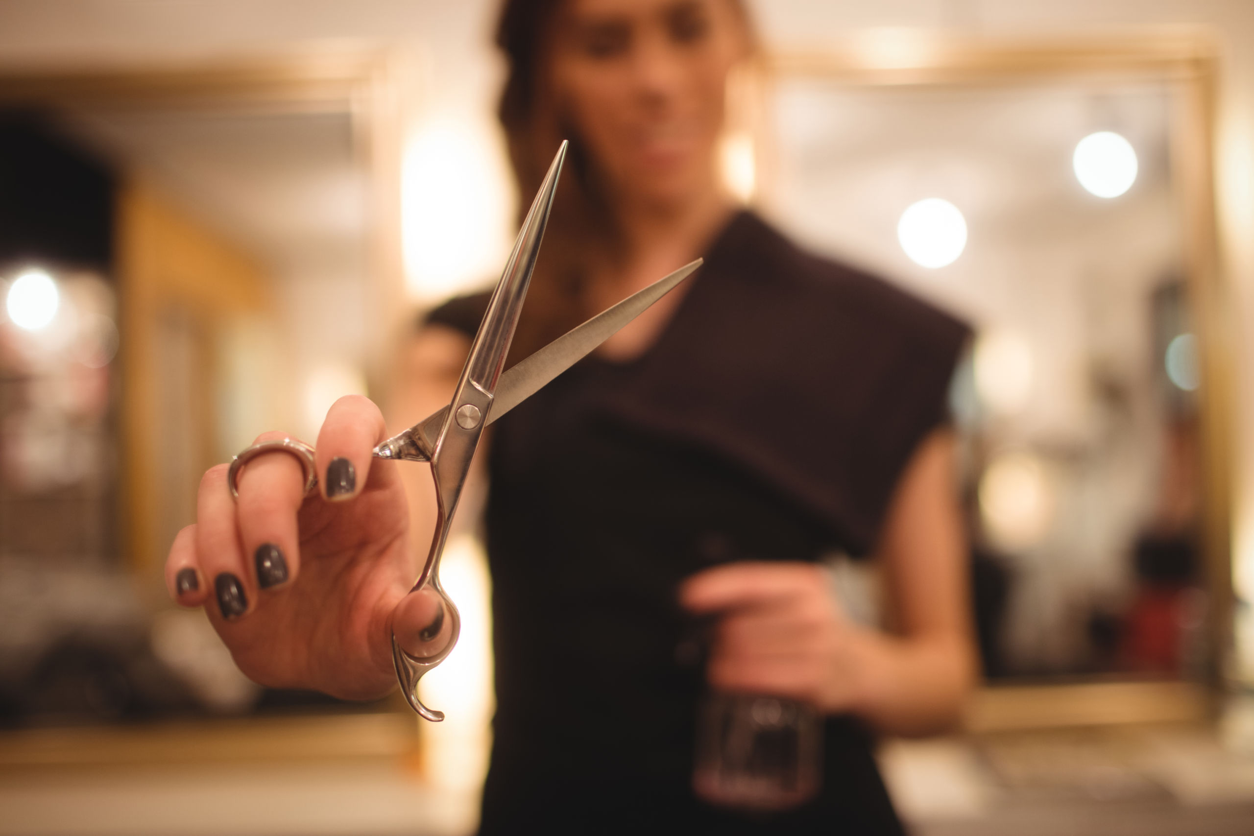 Female hairdresser holding scissor at saloon